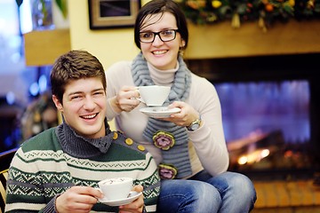 Image showing Young romantic couple relax on sofa in front of fireplace at hom