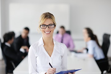 Image showing business woman standing with her staff in background