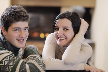 Image showing Young romantic couple sitting and relaxing in front of fireplace