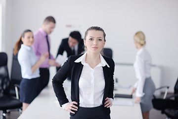 Image showing business woman standing with her staff in background