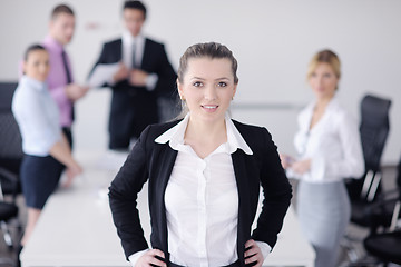 Image showing business woman standing with her staff in background