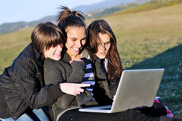 Image showing group of teens working on laptop outdoor