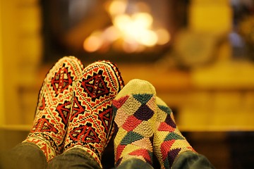 Image showing Young romantic couple sitting on sofa in front of fireplace at h
