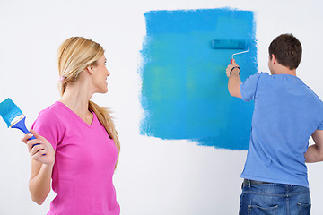 Image showing happy couple paint wall at new home