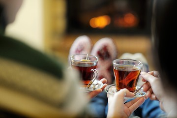 Image showing Young romantic couple relax on sofa in front of fireplace at hom