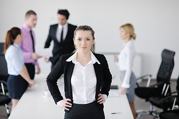 Image showing business woman standing with her staff in background