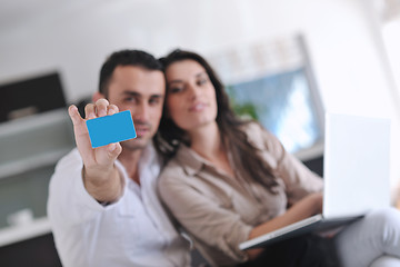 Image showing joyful couple relax and work on laptop computer at modern home