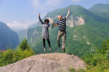 Image showing happy young couple jumping in the air