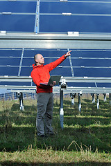 Image showing engineer using laptop at solar panels plant field