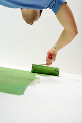 Image showing handsome young man paint white wall in color