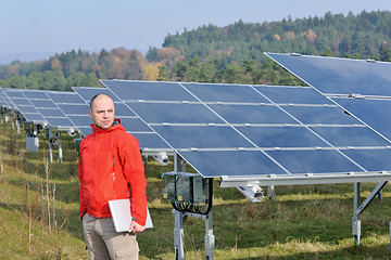 Image showing engineer using laptop at solar panels plant field