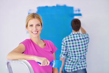 Image showing happy couple paint wall at new home