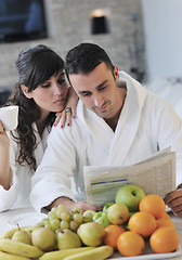 Image showing Happy couple reading the newspaper in the kitchen at breakfast