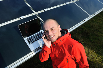 Image showing engineer using laptop at solar panels plant field