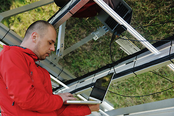 Image showing engineer using laptop at solar panels plant field