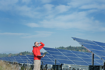 Image showing engineer using laptop at solar panels plant field