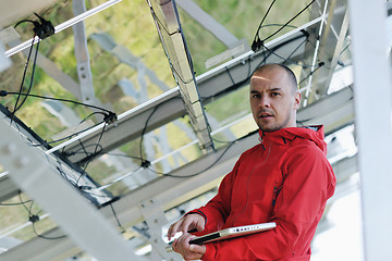 Image showing engineer using laptop at solar panels plant field