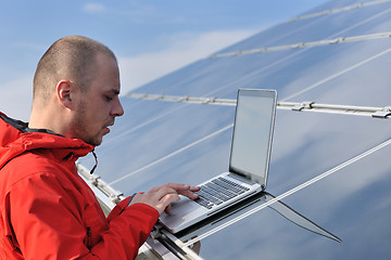 Image showing engineer using laptop at solar panels plant field