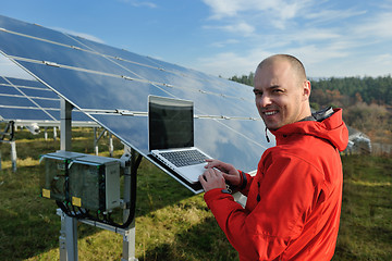 Image showing engineer using laptop at solar panels plant field