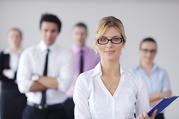 Image showing business woman standing with her staff in background