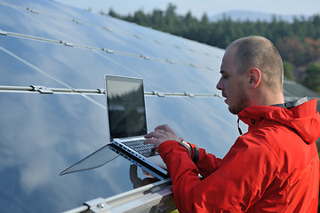 Image showing engineer using laptop at solar panels plant field