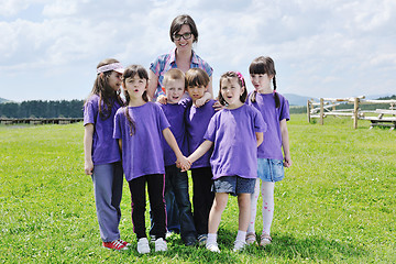 Image showing happy kids group with teacher in nature