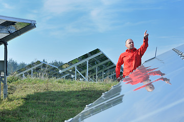 Image showing engineer using laptop at solar panels plant field