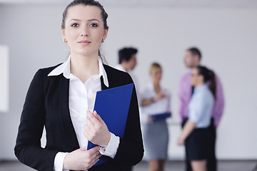 Image showing business woman standing with her staff in background