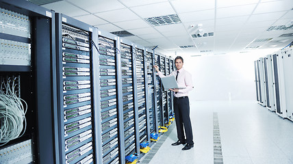 Image showing businessman with laptop in network server room