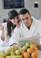 Image showing Happy couple reading the newspaper in the kitchen at breakfast