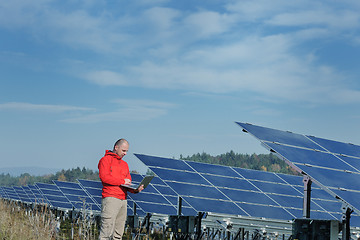 Image showing engineer using laptop at solar panels plant field