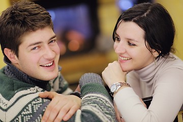 Image showing Young romantic couple relax on sofa in front of fireplace at hom