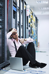 Image showing businessman with laptop in network server room