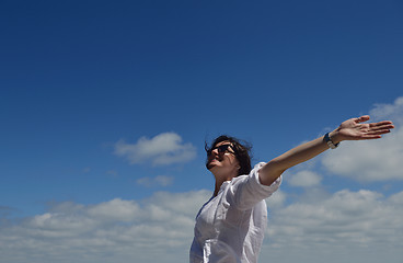 Image showing happy young woman with spreading arms to sky