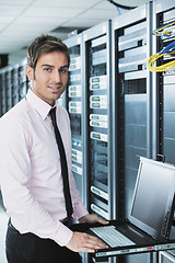 Image showing businessman with laptop in network server room