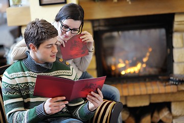 Image showing Young romantic couple relax on sofa in front of fireplace at hom