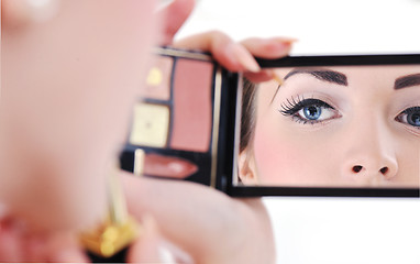 Image showing beautiful young woman applying makeup