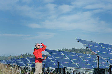 Image showing engineer using laptop at solar panels plant field