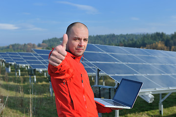 Image showing engineer using laptop at solar panels plant field