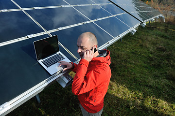 Image showing engineer using laptop at solar panels plant field