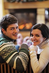 Image showing Young romantic couple sitting on sofa in front of fireplace at h