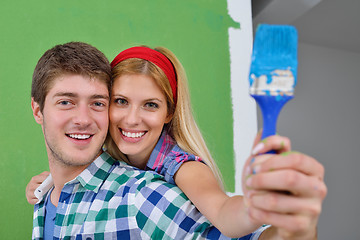 Image showing happy couple paint wall at new home