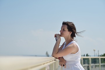 Image showing young woman with spreading arms to sky