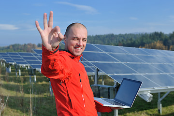 Image showing engineer using laptop at solar panels plant field