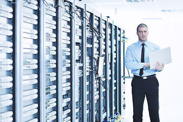 Image showing businessman with laptop in network server room