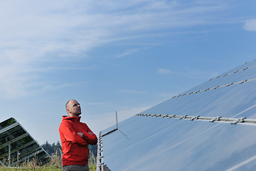 Image showing engineer using laptop at solar panels plant field