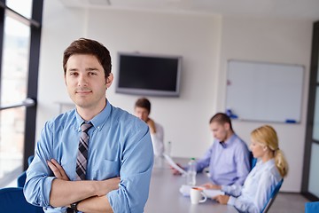 Image showing business man  on a meeting in offce with colleagues in backgroun