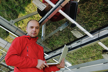 Image showing engineer using laptop at solar panels plant field