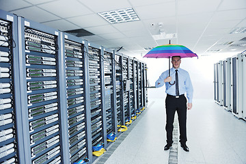 Image showing businessman hold umbrella in server room