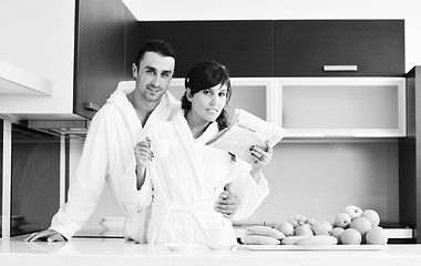 Image showing Happy couple reading the newspaper in the kitchen at breakfast